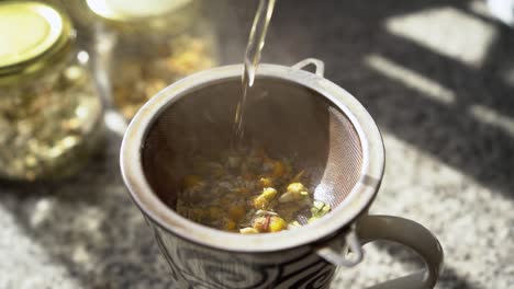 verter agua caliente en una taza para preparar té de hierbas