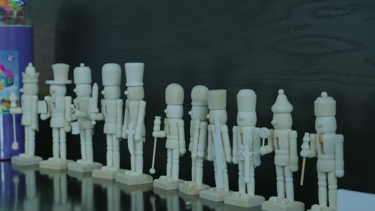 A close-up lineup of blank wooden nutcracker soldiers.