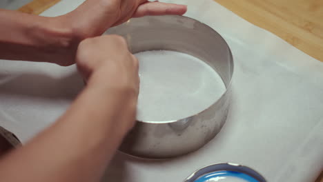 Woman-greasing-circular-pan-with-cooking-oil