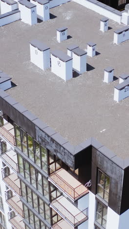 contemporary exterior of high-raised building. new public housing apartments in the city of modern design. motion camera top down. vertical video