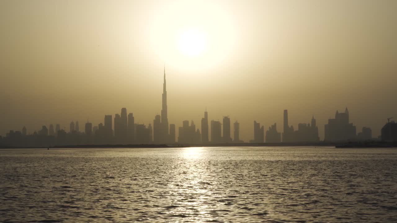 Tramonto giallo brillante che splende sullo skyline di Dubai e su Dubai Creek negli EAU, Medio Oriente