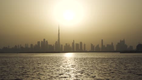 bright yellow sunset shining over dubai skyline and dubai creek in uae, middle east