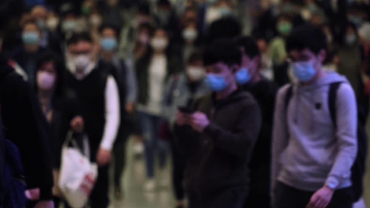 Hong Kong, China - March 20, 2020: Slow motion of people wearing medical face masks at metro in Hong Kong.