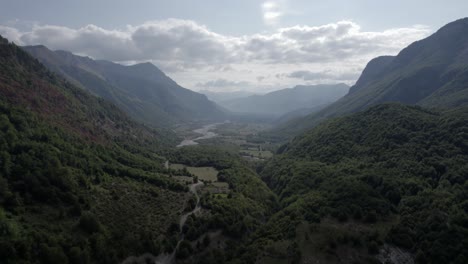 drone video of frontal plane advancing over the vermosh valley above the vermoshi river, the sh20 at the height of bashkimi, albania