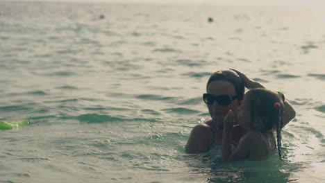 silhouettes-of-mommy-and-girl-diving-in-calm-ocean-waves