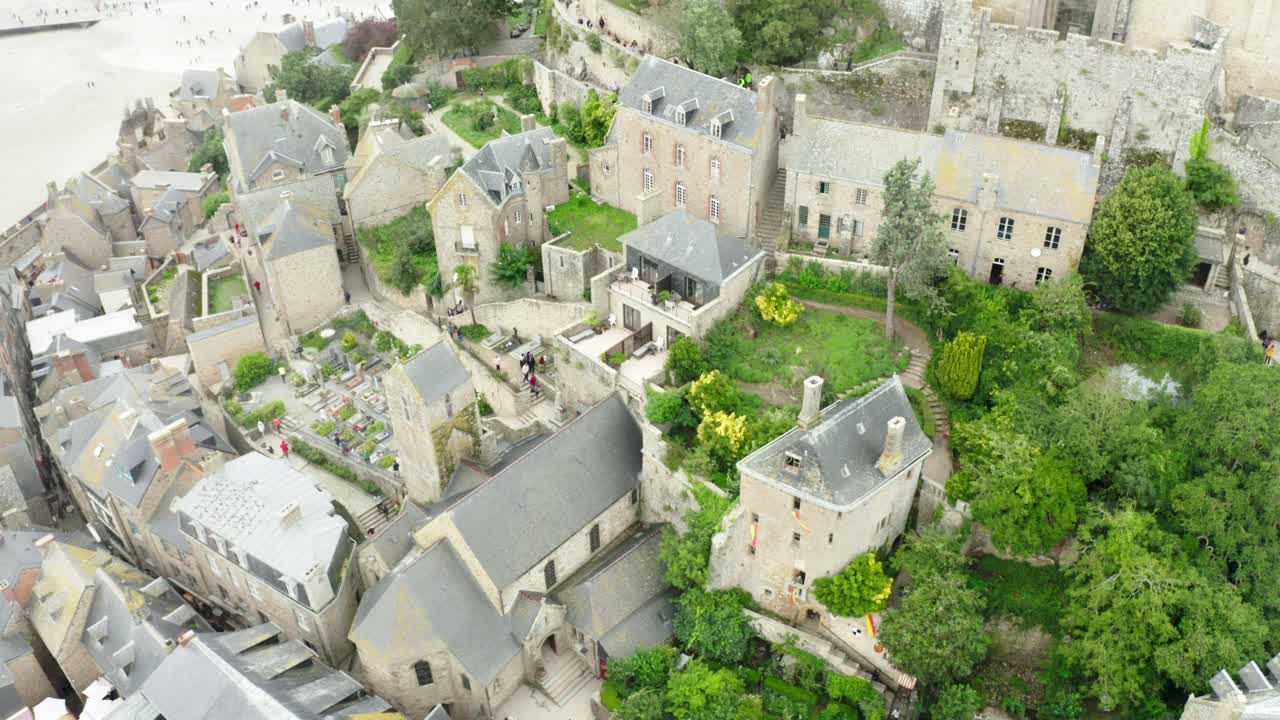 몬트 세인트 미 ⁇  성의 공중 드론 뷰에는 큰 정원과 사진을 찍는 관광객들이 있습니다.