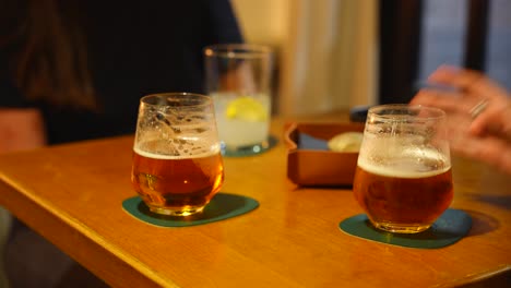 Three-people-pick-up-glasses-simultaneously-at-a-cozy-table-with-warm-lighting