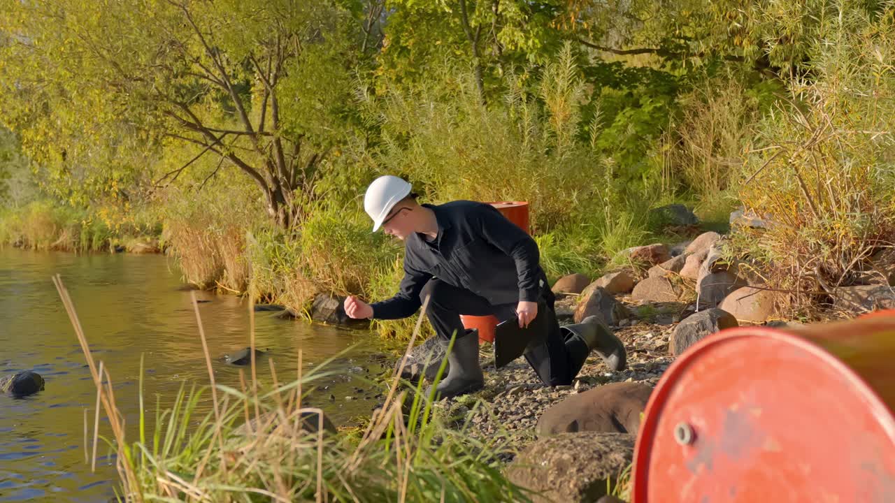 Person tests water quality by a river showing pollution concern