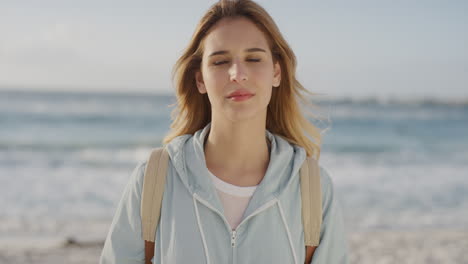 ritratto di una bella donna bionda sulla spiaggia che guarda calma pensierosa alla telecamera sullo sfondo caldo dell'estate sul mare