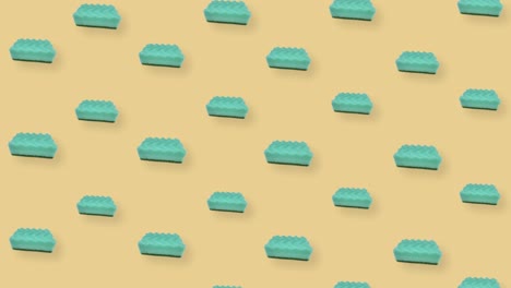 patrón colorido de esponjas de cocina verdes en fondo naranja. patrón sin costuras con esponja. vista superior. animación realista. movimiento de video 4k