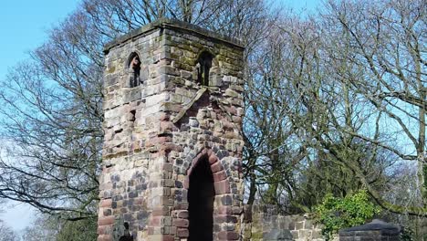 Historic-Windleshaw-Chantry-stonework-tower-exterior-slow-motion-around-graveyard-ruins-against-blue-sky