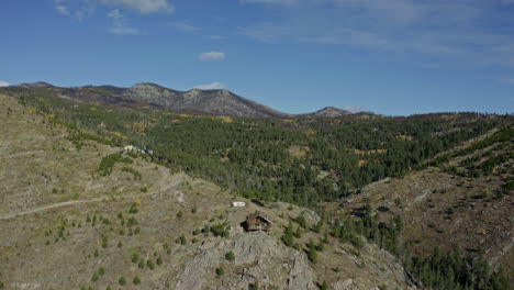 movimiento aéreo más allá de una pequeña cabaña remota en un afloramiento en la ladera de la montaña, 4k