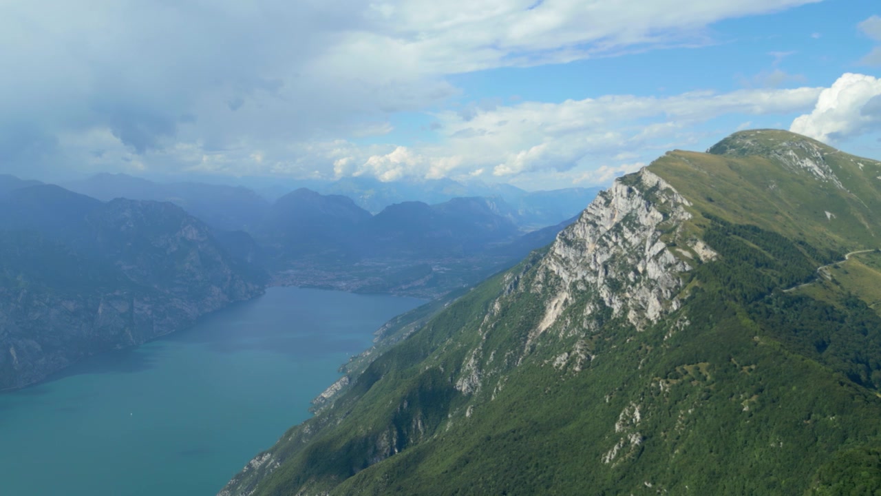 Vista aerea che si affaccia sulla cresta del Monte Baldo sopra il Lago di Garda in una giornata parzialmente nuvolosa