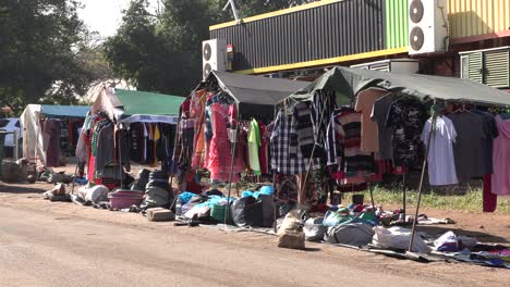 a small african market with vibrant fabrics, displaying a variety of clothing