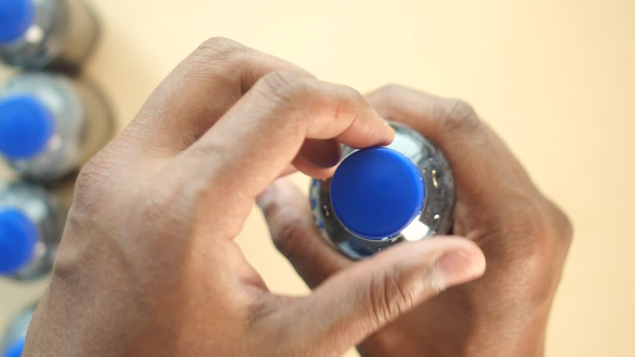 una persona abriendo una botella de agua