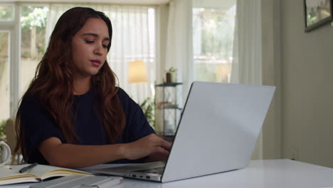 una chica infeliz escribiendo en la computadora portátil.