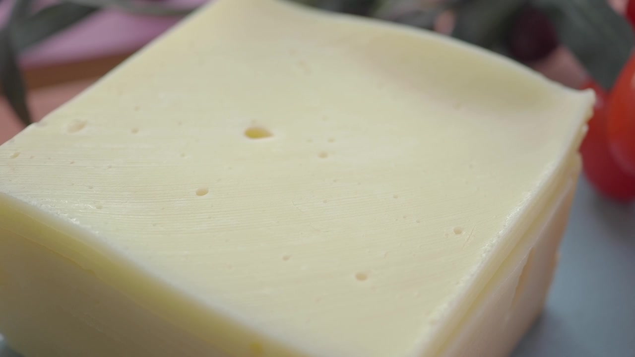 Primo piano di un blocco di formaggio svizzero con pomodorini