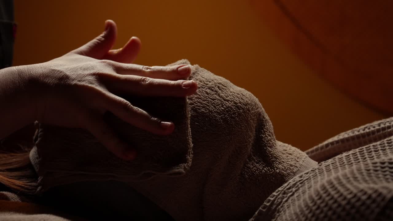 Donna che riceve un rilassante trattamento viso con asciugamano caldo in una spa