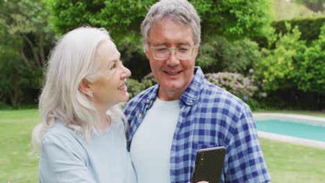 animation of caucasian senior couple embracing in garden, taking selfie