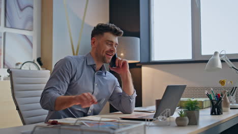 smiling boss negotiating cellphone at modern agency closeup. man drinking tea