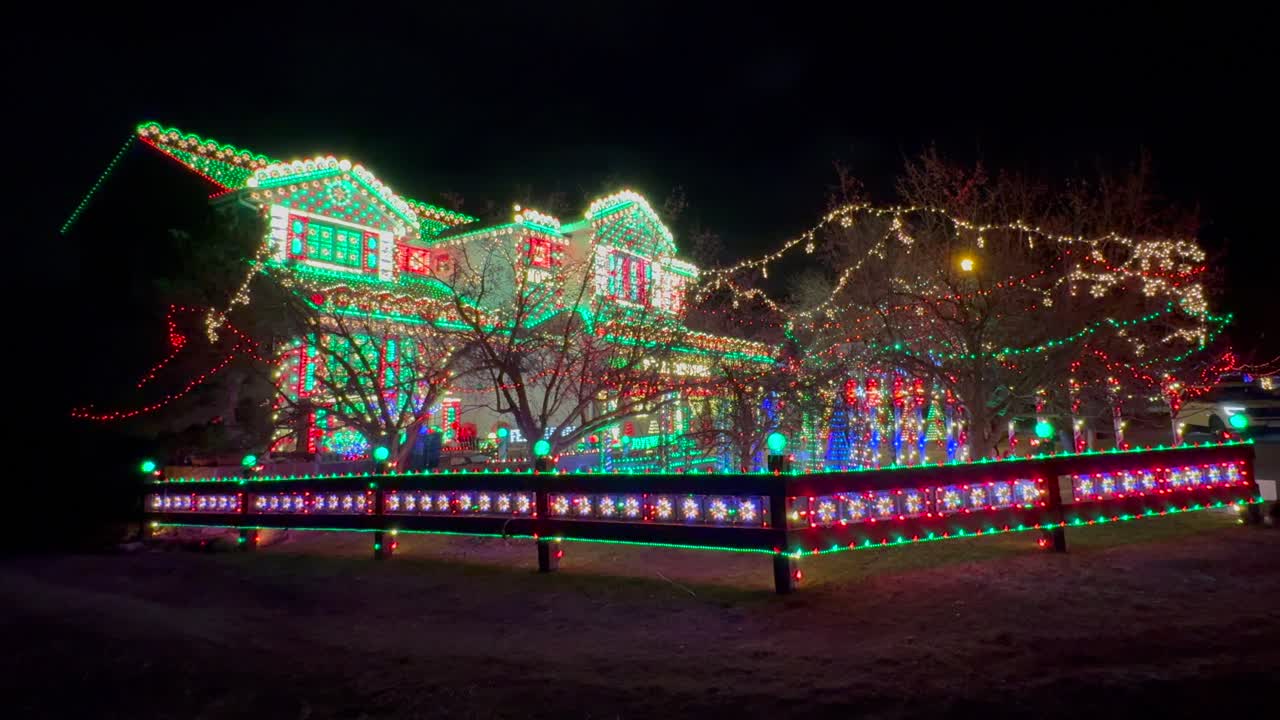 Gingerbread Candy cane lane house vibrant lights home Merry Christmas trees Happy Holidays decoration Highlands Ranch Denver Colorado USA night time bright hanging branch neighborhood pan down