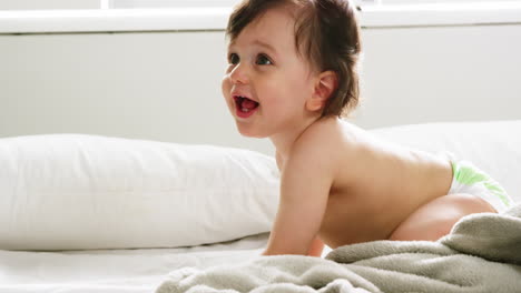 un bebé lindo jugando en una cama