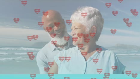 animación de iconos de corazón sobre una feliz pareja afroamericana de alto nivel en la playa