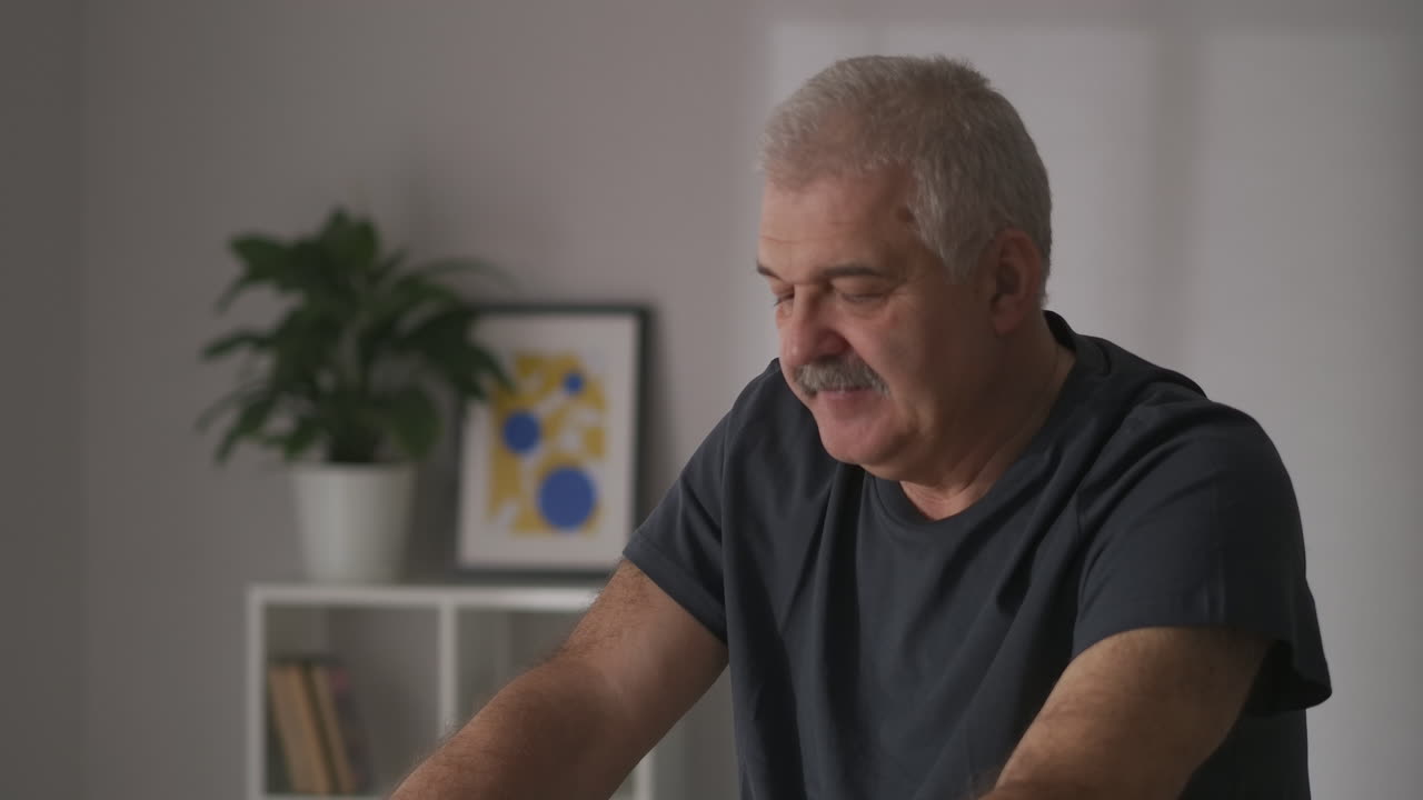 entrenamiento en bicicleta estacionaria para personas con enfermedades cardiovasculares hombre de mediana edad hace ejercicio en casa usando equipos deportivos modernos