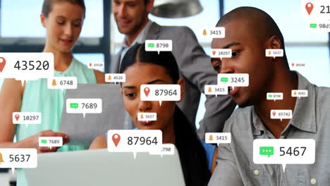 Compuesto-De-íconos-De-Notificación-Con-Números-Cambiantes-Sobre-Diversos-Colegas-Discutiendo-Sobre-Una-Computadora-Portátil