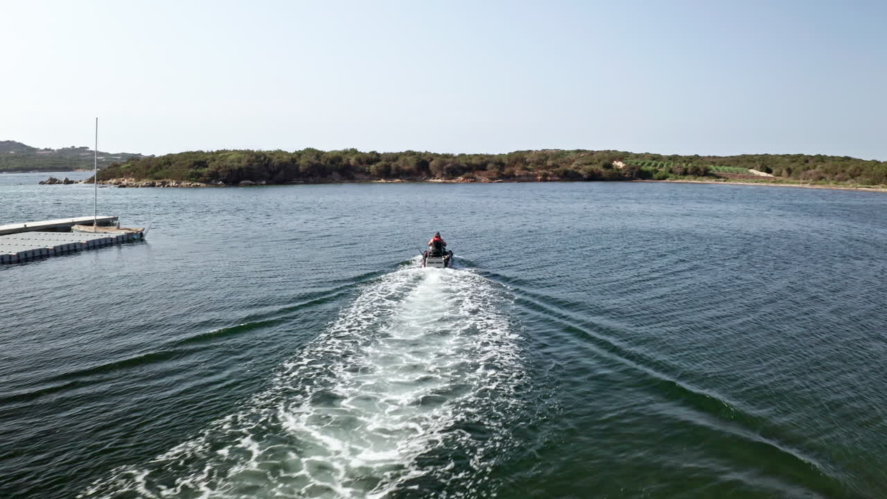Jet ski speeding on clear blue waters of Sardinia on a sunny day, aerial view