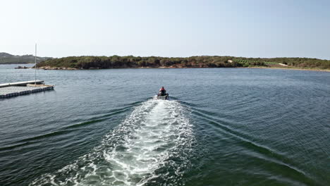 jet ski speeding on clear blue waters of sardinia on a sunny day, aerial view