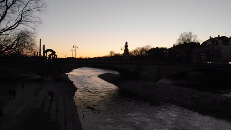 vista de la puesta de sol de un puente sobre el río isar munich alemania