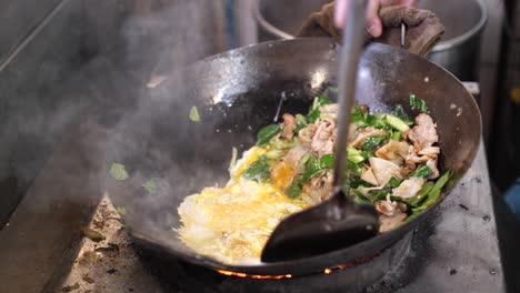 thai street food : chef preparing cooking thai stir fried noodles with egg, vegetable, pork and soy sauce - pad see ew, one of the popular thai dishes, slow motion 4k