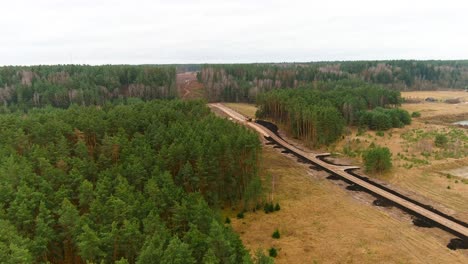 freshly build gravel road in woodland area, aerial drone view
