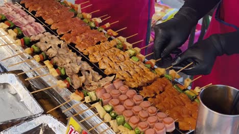 street food vendor grilling assorted skewers