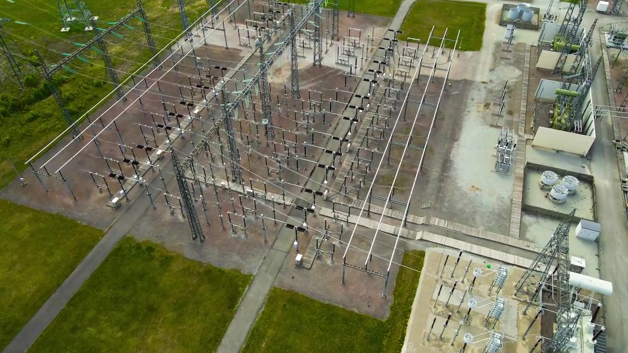Luftaufnahme eines Hochspannungs-Umspannwerks. Industrielle Stromleitungen und Transformatoren, die Energie über das Netz verteilen.