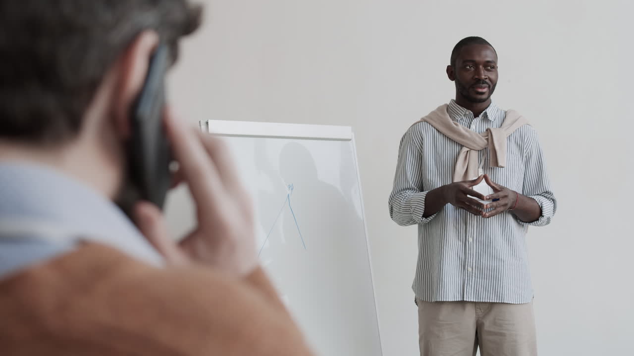 Man Making Presentation when Colleague Calling on Phone