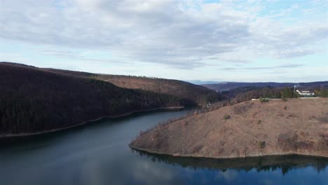 slow rotating reveal of the dam on the lake cincis, surrounded by the mountains