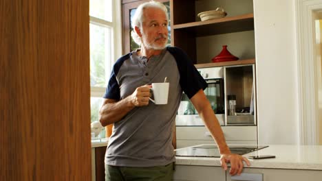 Senior-man-having-coffee-in-kitchen-at-home-4k