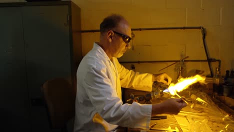 Side-view-of-mature-male-worker-creating-glass-in-glass-factory-4k