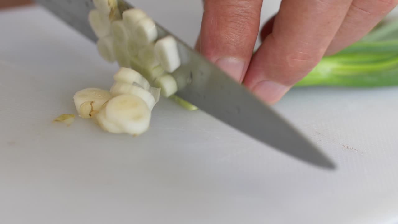 Chopping spring onion, Close-Up. hands cut Spring onions in kitchen, 60FPS