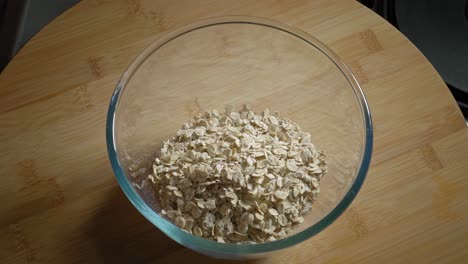 pouring oat flakes into a bowl then add cottage cheese, eggs, and water