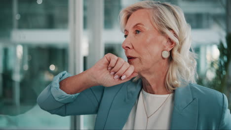 a businesswoman in a blue suit looks thoughtfully away from the camera while standing in an office.