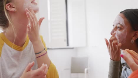 diversas adolescentes felices amigos haciendo maquillaje en casa, cámara lenta