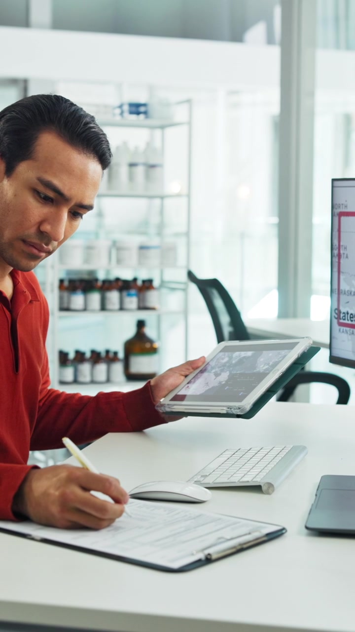 Hombre profesional revisando datos en una tablet y escribiendo notas en la oficina
