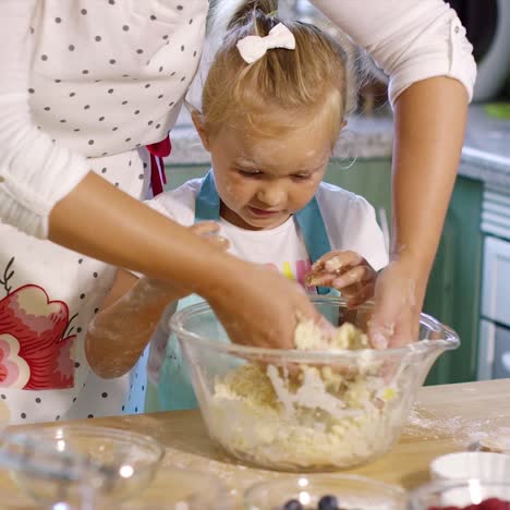 cute little girl kneading baking ingredients