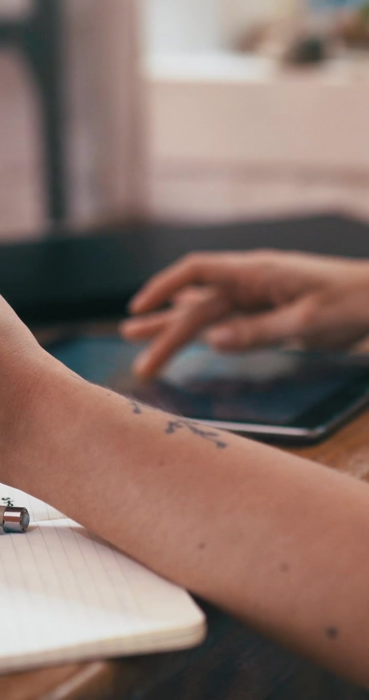 Person hält Kreditkarte in der Hand und nutzt Tablet zum Online-Shopping