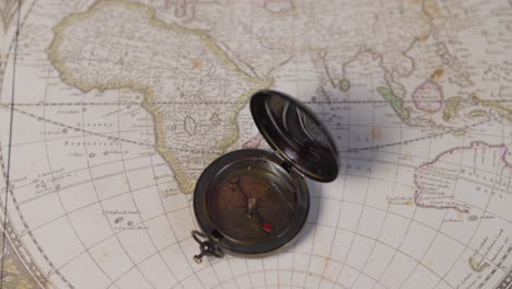 an atique brass compass on a vintage world map