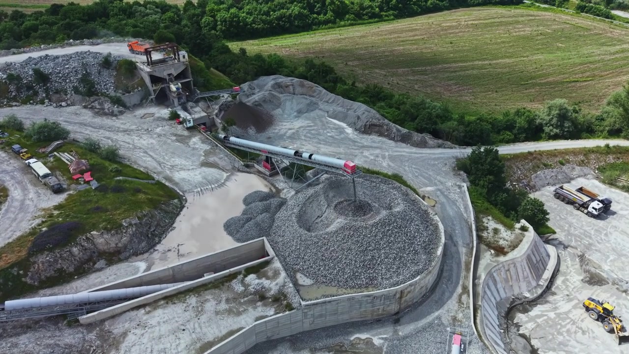 Industrial stone processing. Largescale limestone processing facility with transport vehicles. Expansive construction site featuring conveyor systems and material stockpiles