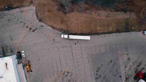 Von-Oben-Nach-Unten-Zeigt-Ein-Weißer-Sattelschlepper,-Der-Am-Seitenstreifen-Einer-Raststätte-Geparkt-Ist